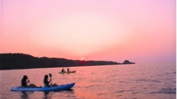 沖縄のサンセットシーカヤック体験。夕暮れの空に染まる海を進み、静かな波と風を感じながら幻想的な時間を過ごせる。