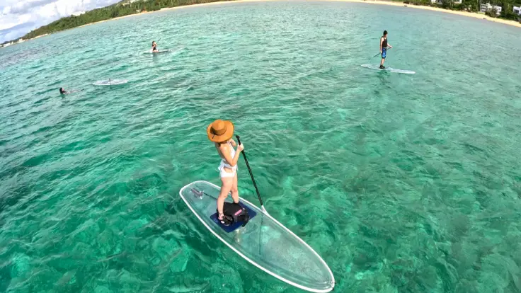 沖縄の海で朝のSUPを楽しむ様子。風が穏やかで初心者でも漕ぎやすく、快適に体験できる時間帯。