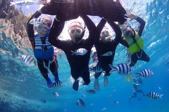 青の洞窟に綺麗なポイントでシュノーケリングをしているファミリー