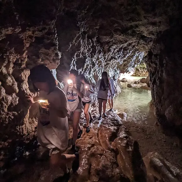 干潮時間に出現する洞窟を探検している女性達