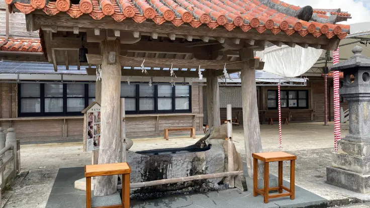 普天満宮の手水舎。竹筒から流れる水音が心地よく、作法の案内板も添えられている。