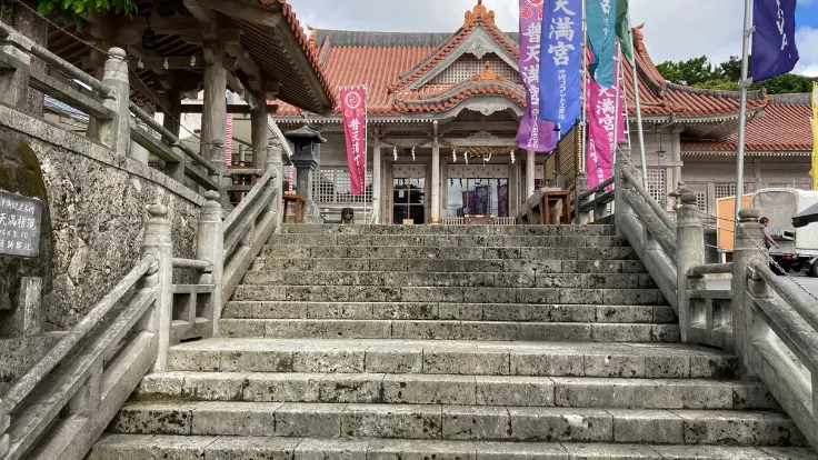 普天満宮の境内。赤瓦の拝殿と石段が美しく調和し穏やかな雰囲気が漂う。