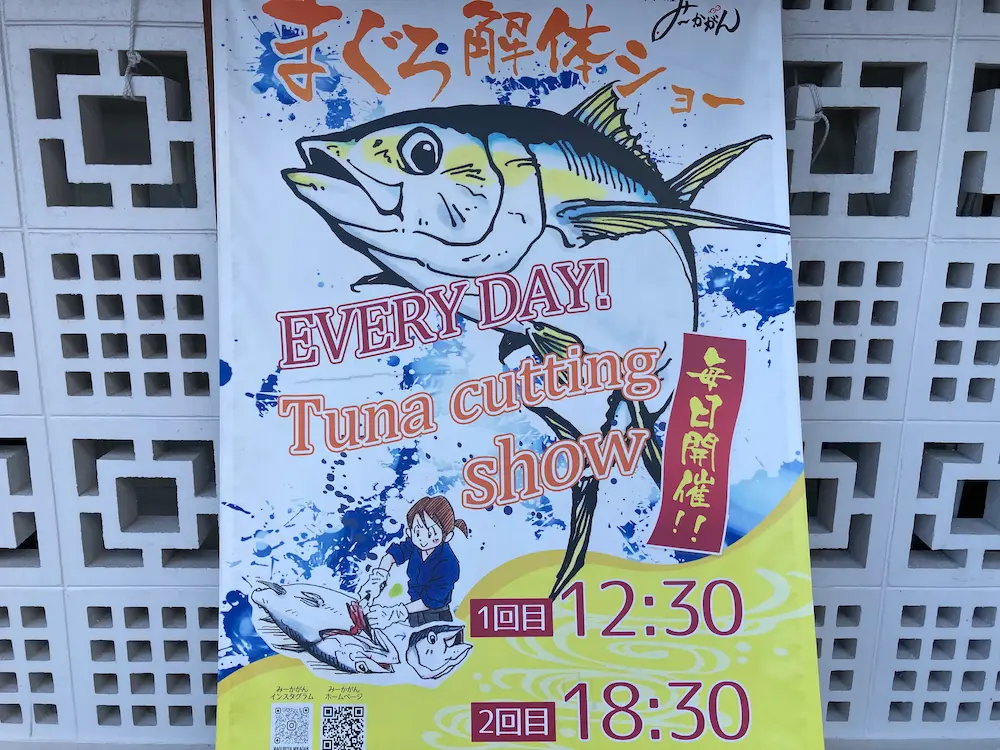 毎日2回開催されるマグロ解体ショーの案内板>
  <p class=