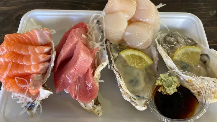 いとまんの海鮮（マグロ、サーモン、ホタテ、カキ）がお皿に並んでいる