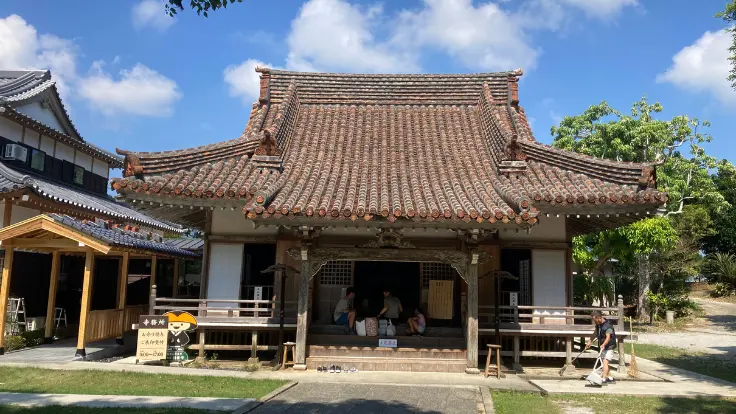 金武観音寺の本堂。静かな木造建築が緑に映え、地域の人々の信仰心に支えられている。