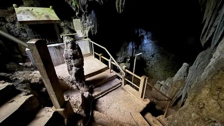 金武観音寺の鍾乳洞内部に祀られた金武宮の祠。岩壁と鍾乳石に囲まれ、探検気分が味わえる空間。