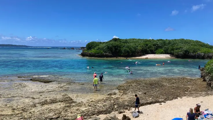 備瀬崎の穴場シュノーケルエリア。遠浅の海に色とりどりの熱帯魚が泳ぎ、透明な水中にサンゴや岩場が点在している。