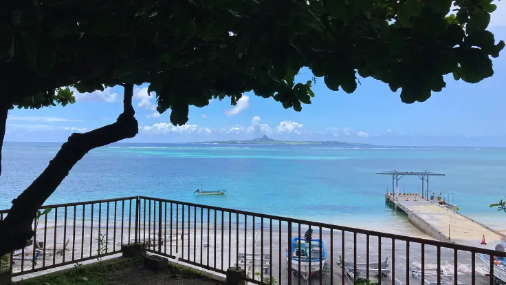 備瀬から望む伊江島と海の風景。青く澄んだ海の向こうに、特徴的な伊江島タッチューが見えている。