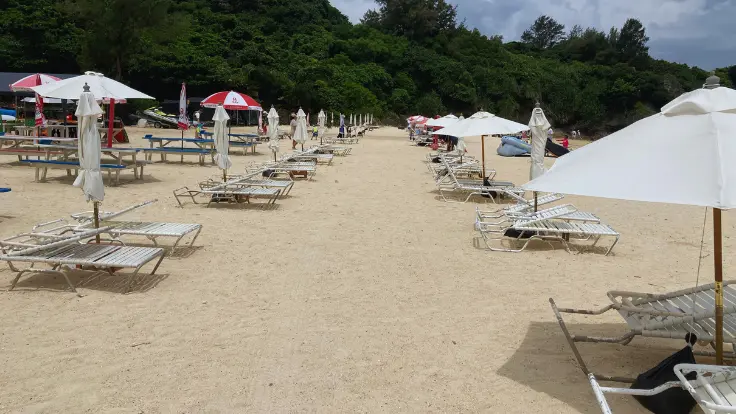 アンチ浜のビーチチェアとパラソル。白い砂浜で日差しをよけながらのんびり過ごせるレンタルサービス。