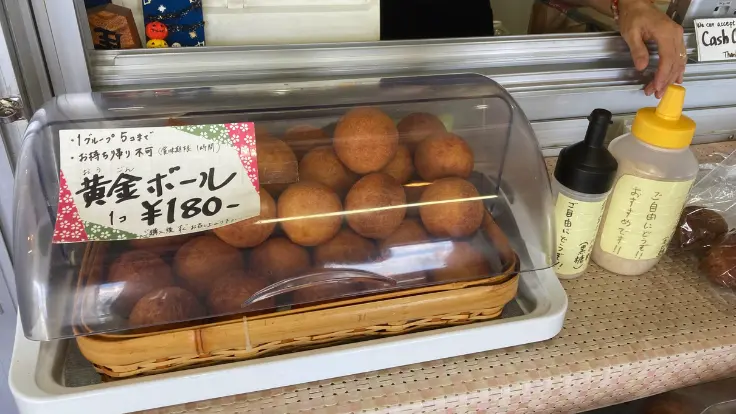 道の駅許田の三矢本舗で販売されているサーターアンダギー。プレーン・黒糖・紅いもなど、地元でも人気の味が並ぶ。