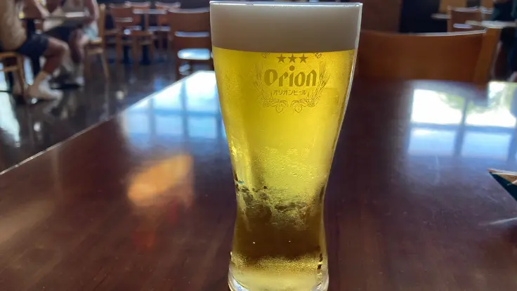 黄金色に輝くできたてのオリオンビールがグラスに2杯並ぶ試飲シーン。旅のごほうびのようなひとときが楽しめる