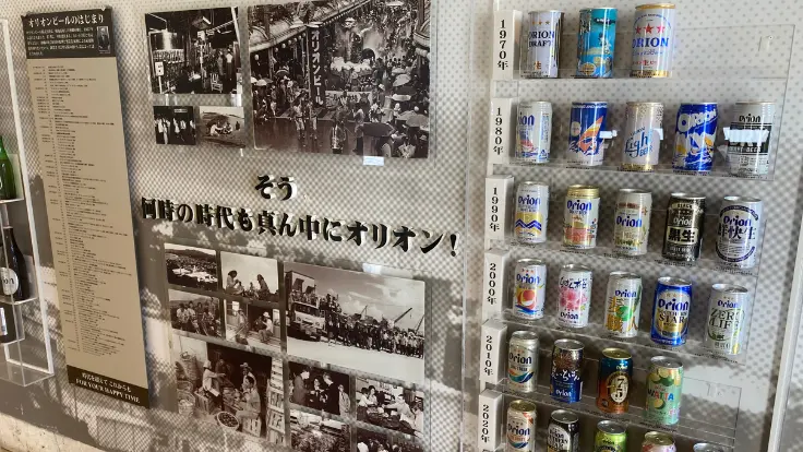 年代ごとのオリオンビール缶や瓶が並ぶ展示。ロゴやデザインの変遷が一目でわかるコーナー