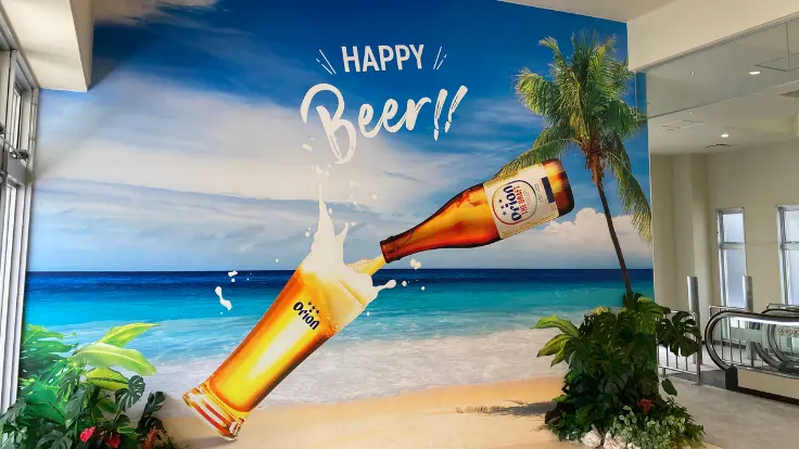 オリオンビールの巨大缶とロゴを背景に記念撮影できる、ハッピーパーク入口の人気フォトスポット