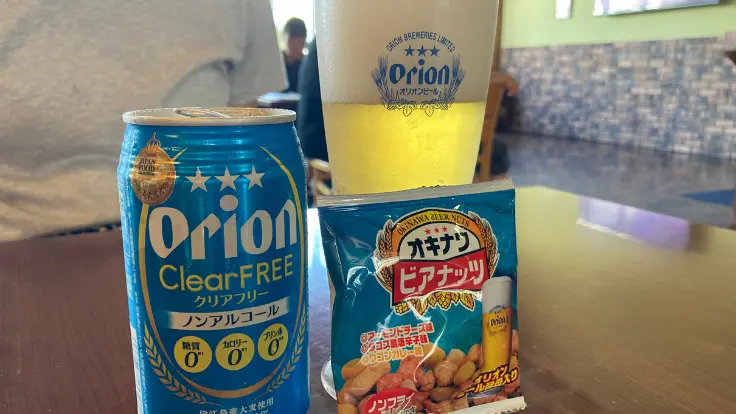 オリオンのノンアルコールビールとソフトドリンクが並ぶ試飲シーン。運転者や子どもにも配慮された提供スタイル