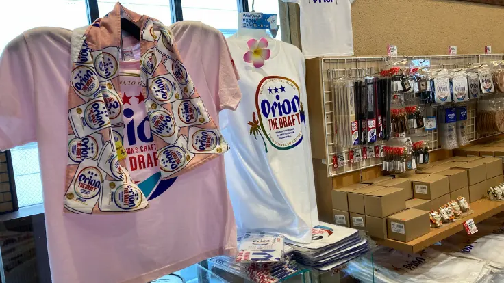 オリオンビールのロゴ入りTシャツや限定グッズが並ぶお土産コーナー。旅の記念になるアイテムが豊富に揃う