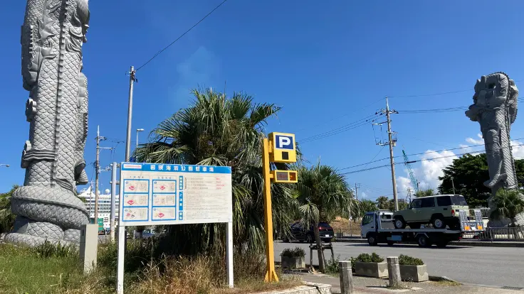 若狭海浜公園駐車場の入口。龍柱が目印で料金も安く、波上宮まではビーチ側から徒歩でアクセスできる。