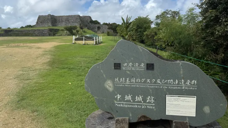 中城城跡の象徴として立つ世界遺産モニュメントと、静かに佇む石垣。歴史の重みを感じさせる風景。
