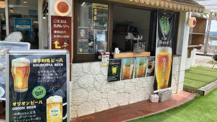 海を背景にした屋外テラスで楽しむ古宇利島限定クラフトビール。リゾート感あふれる至福のひととき。