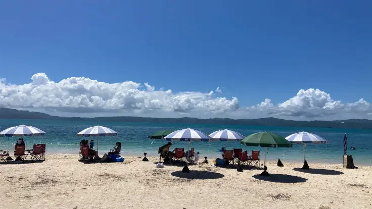 古宇利ビーチの砂浜に並ぶパラソル。日差しをよけて海を眺めながらゆったり過ごせる休憩スポット。