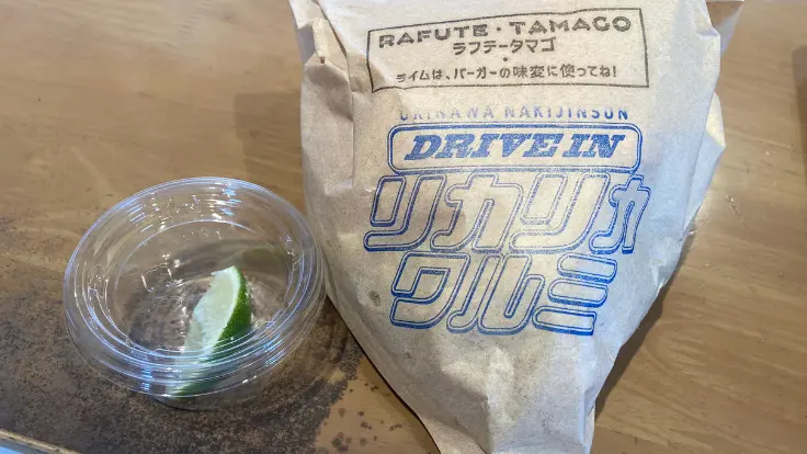 リカリカワルミのラフテーバーガーに添えられたライム。ジューシーな三枚肉に爽やかな酸味をプラスしてくれる演出
