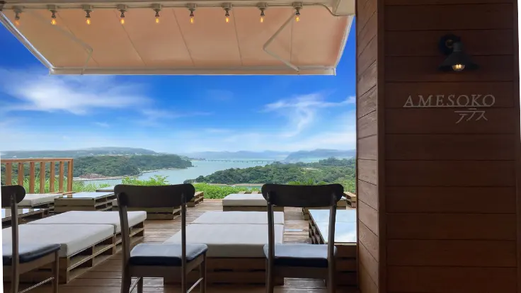 リカリカワルミの絶景テラスから望む海と橋の風景。青空の下、開放感あふれるロケーションが広がっている