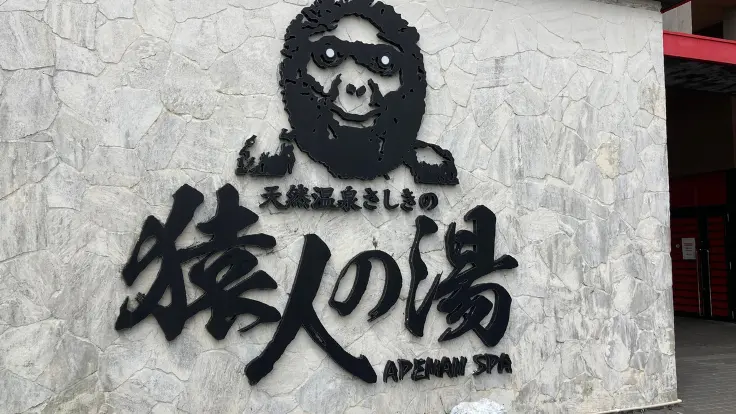 ユインチホテル南城の温泉施設『猿人の湯』の入口外観。壁面には猿のイラストが描かれています