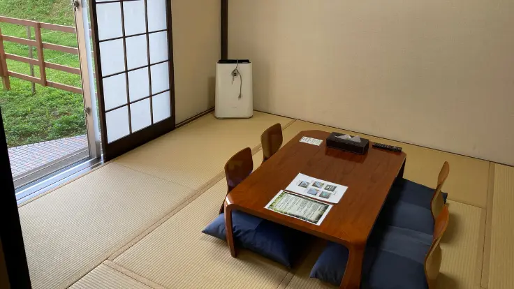 ユインチホテル南城の8畳和室客室。畳と障子が調和した落ち着きのある空間で、窓からは自然が見渡せます