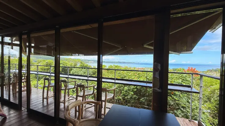 店内の大きな窓から望む、海と森のコントラストが美しい恩納村の風景