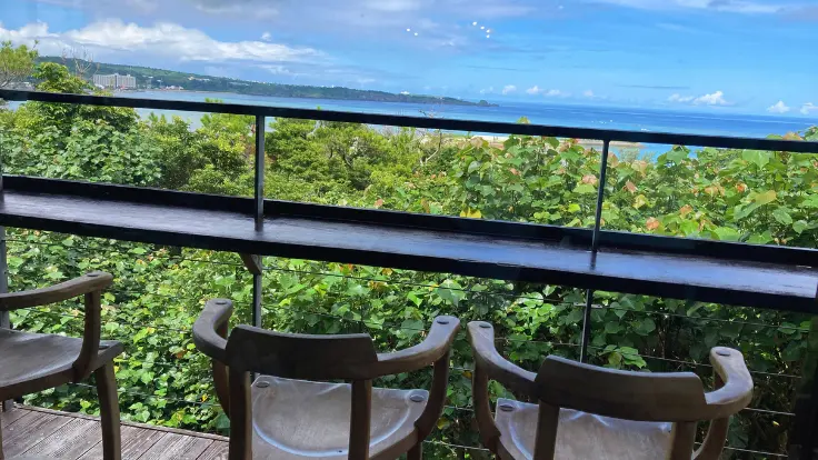 テラス席から望む海と森の絶景。やさしい朝の光に包まれるカフェの風景