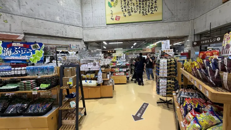おんなの駅 なかゆくい市場の館内お土産コーナー。海ぶどうや恩納もずく、沖縄菓子・調味料などが並ぶ棚の様子。