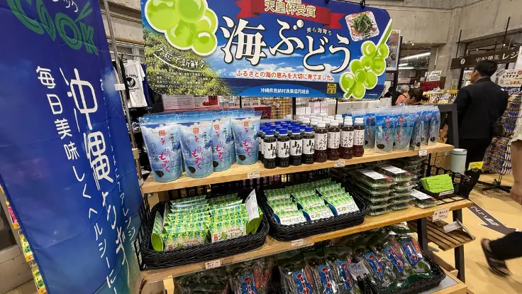 おんなの駅 なかゆくい市場の館内お土産コーナー。海ぶどうや加工品、沖縄菓子が並ぶ棚の様子。