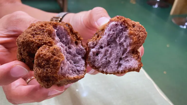 おんなの駅の名物『サーターアンダギー（紅いも味）』。ドライブの合間に食べやすい手のひらサイズのおやつ。