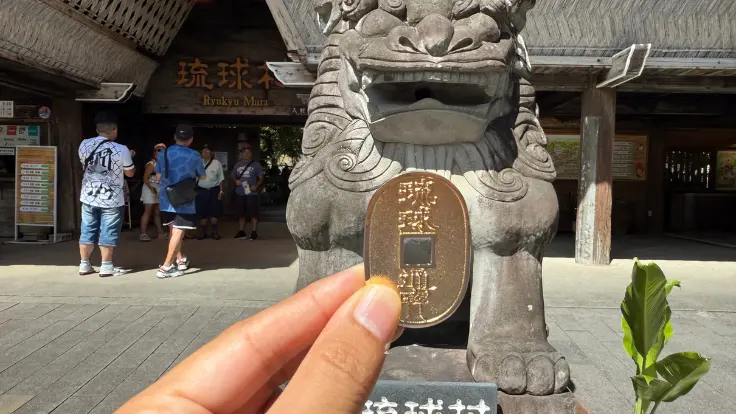 琉球村の入口で手渡される琉球小判。金色にきらめくデザインが印象的。