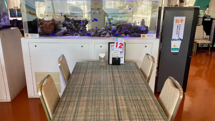 シーサイドドライブイン店内の水槽前の席。熱帯魚がゆったり泳ぎ、落ち着いた雰囲気が漂う。
