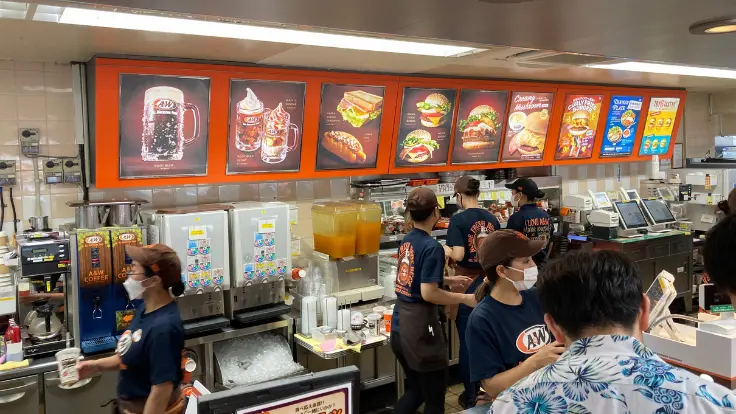 お昼前から行列ができるA&W牧港本店のカウンター。名物ルートビアを飲むか迷うお客さんの姿も。