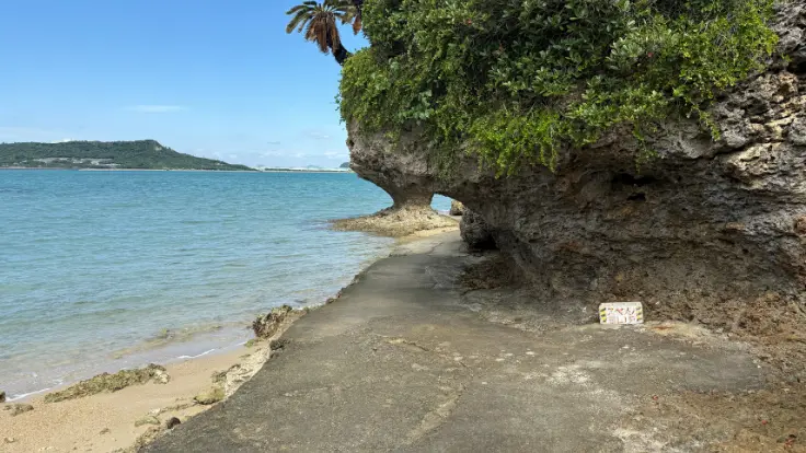 岩の島のまわりを海が囲み、海上の遊歩道がアマミチューの墓へと続いている。