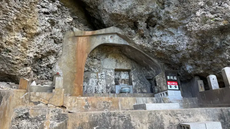 洞穴の中に祀られたアマミチューの墓。石垣に囲まれた拝所と香炉台があり、地元の人々が大切に守ってきた聖なる場所。