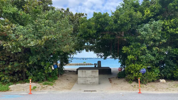 浜比嘉ビーチの入口。島らしい雰囲気の先にビーチが広がり、目の前には無料駐車場が整備されている。