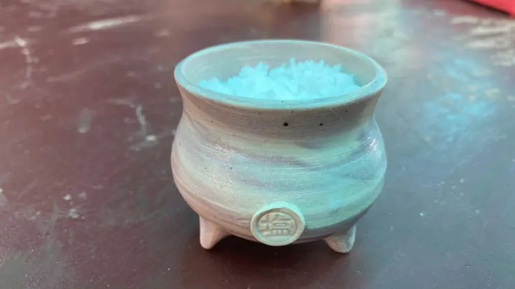 高江洲製塩所で仕上がった塩を、好きな小瓶に詰めて持ち帰る工程。自分だけの“島塩”が作れる体験の仕上げ。