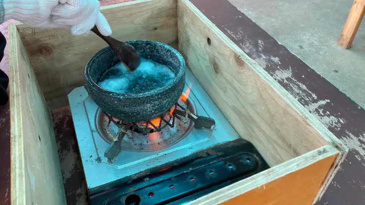 高江洲製塩所で、濃縮した海水を火にかけてかき混ぜながら蒸発させている工程。ゆっくり水分を飛ばし、塩の結晶を仕上げていく様子。