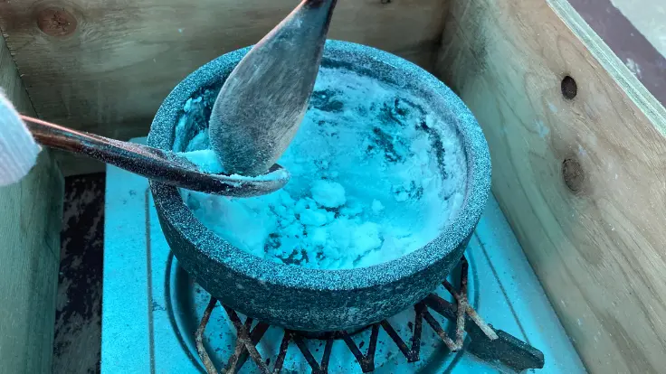 高江洲製塩所で、加熱しながら水分が抜けて塩が白く結晶化してきた工程。へらで混ぜると、ふわっと固まりが見えてくる仕上げの段階。