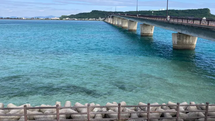浜比嘉島に渡ってすぐの駐車場から見える海の風景。透明度の高い青い海が広がり、島らしい静かな雰囲気が感じられる。