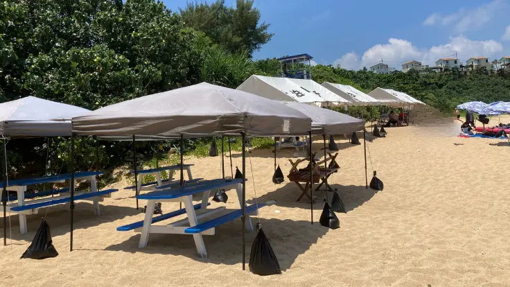 大泊ビーチの砂浜に設置されたレンタルテント。透明な海を眺めながらゆったり過ごせる