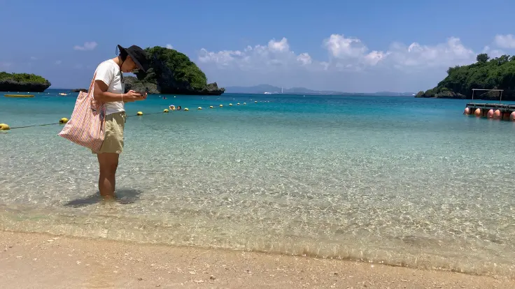 伊計ビーチの海辺。すばらしい透明度の海が広がり、足だけでも心地よく癒やされる景色。