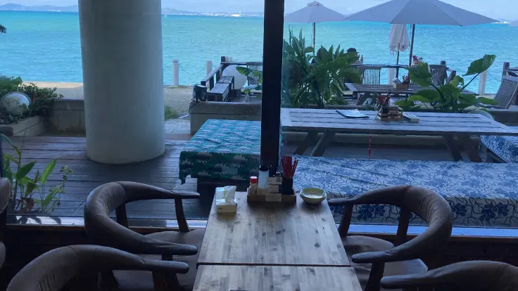 海中茶屋のテーブル席から海を眺めているようす。窓の外には青い海と空が広がる。