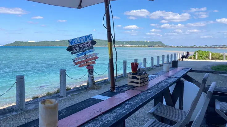 海中茶屋のデッキ席から目の前の海を眺めている様子。手すりの向こうにエメラルドブルーの海が広がる。
