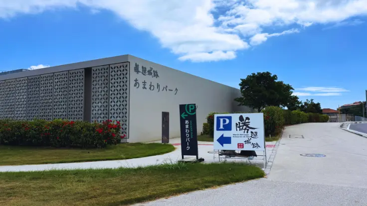 勝連城跡の駐車場と、ふもとに建つあまわりパークの外観。訪れる人を迎える学びの拠点となっている。