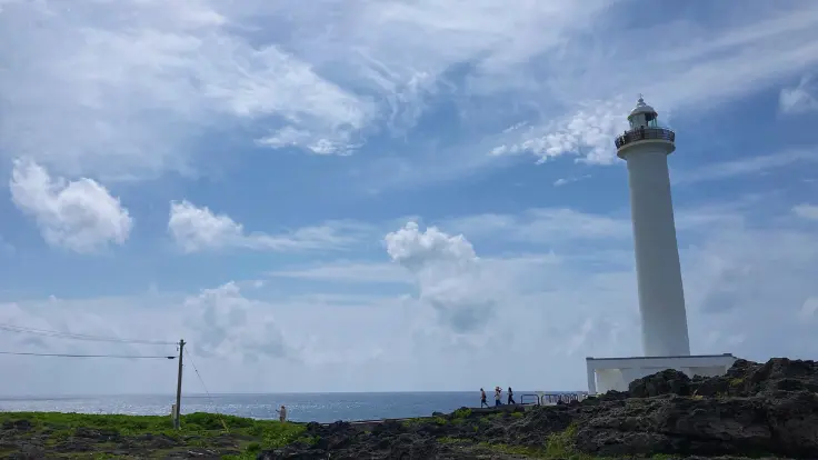 残波岬の白い灯台が空に映える風景。青空とのコントラストが美しく、周囲は見晴らしのよい散策エリア。