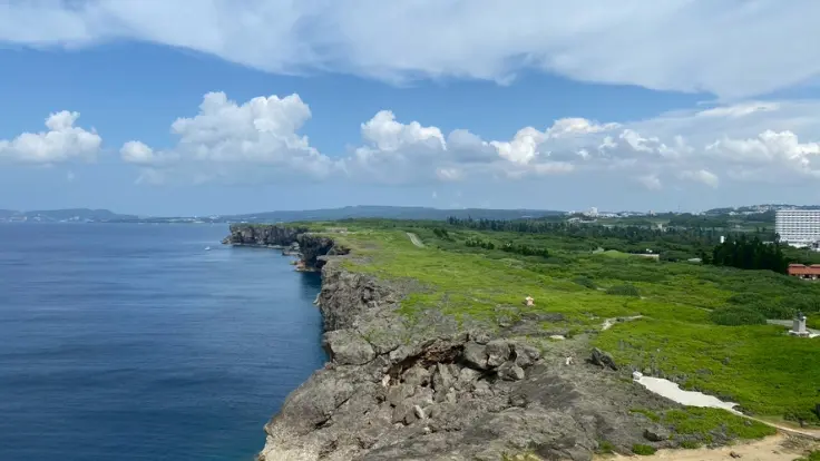 残波岬灯台の上から見下ろす海と崖が広がるパノラマ風景。