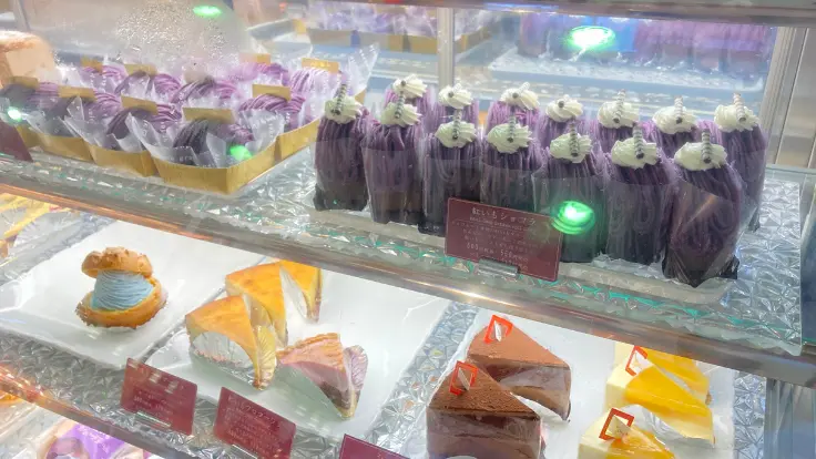 読谷村特産の紅芋を使ったスイーツが並ぶ店内ショーケース。鮮やかな紫色のケーキやアイスが目を引く。
